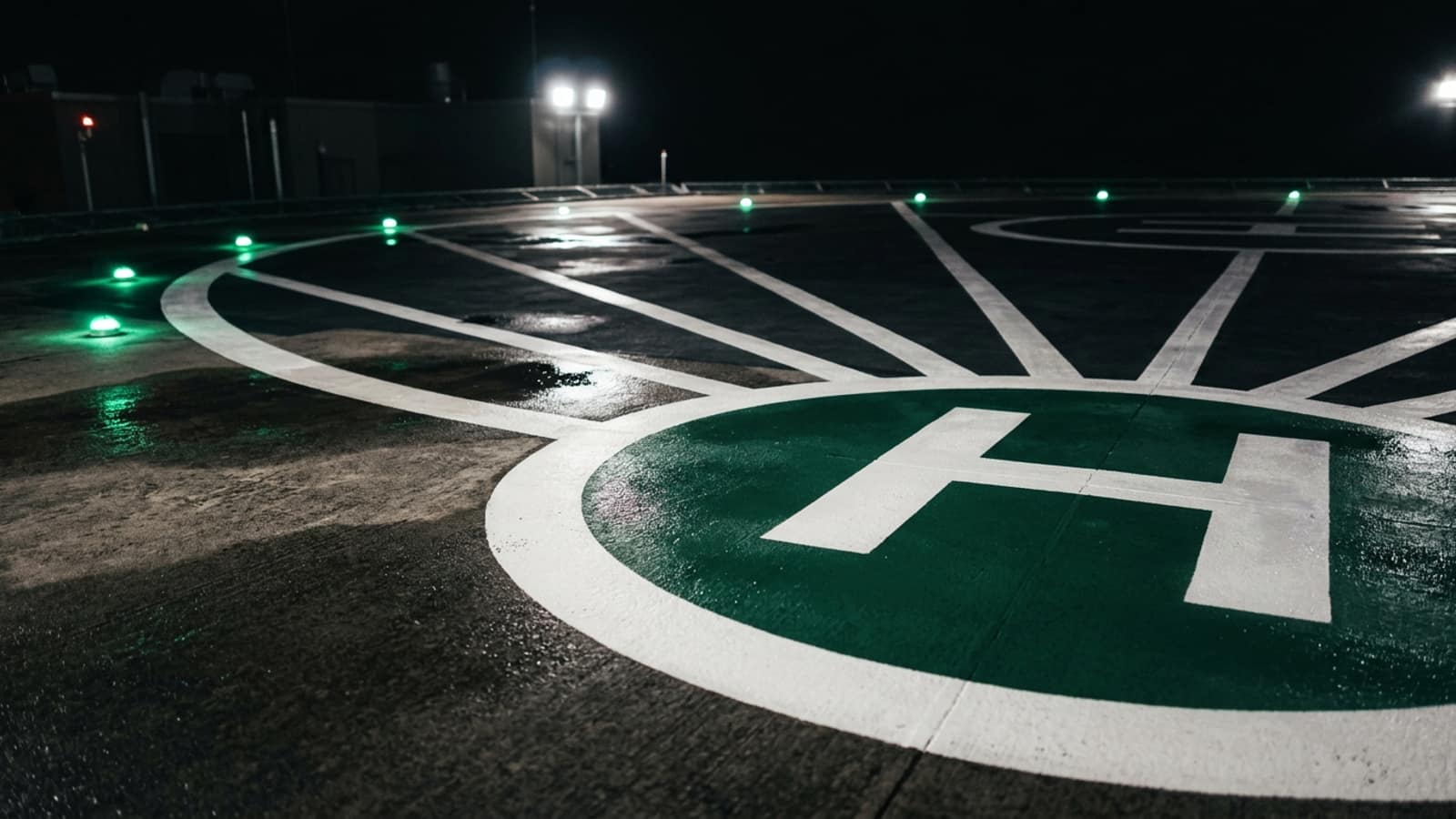 Gece heliport: yanan yeşil çevre ışıkları ve aydınlatılmış beyaz iniş işaretleri